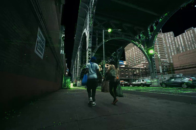 a couple of people walking down a street at night