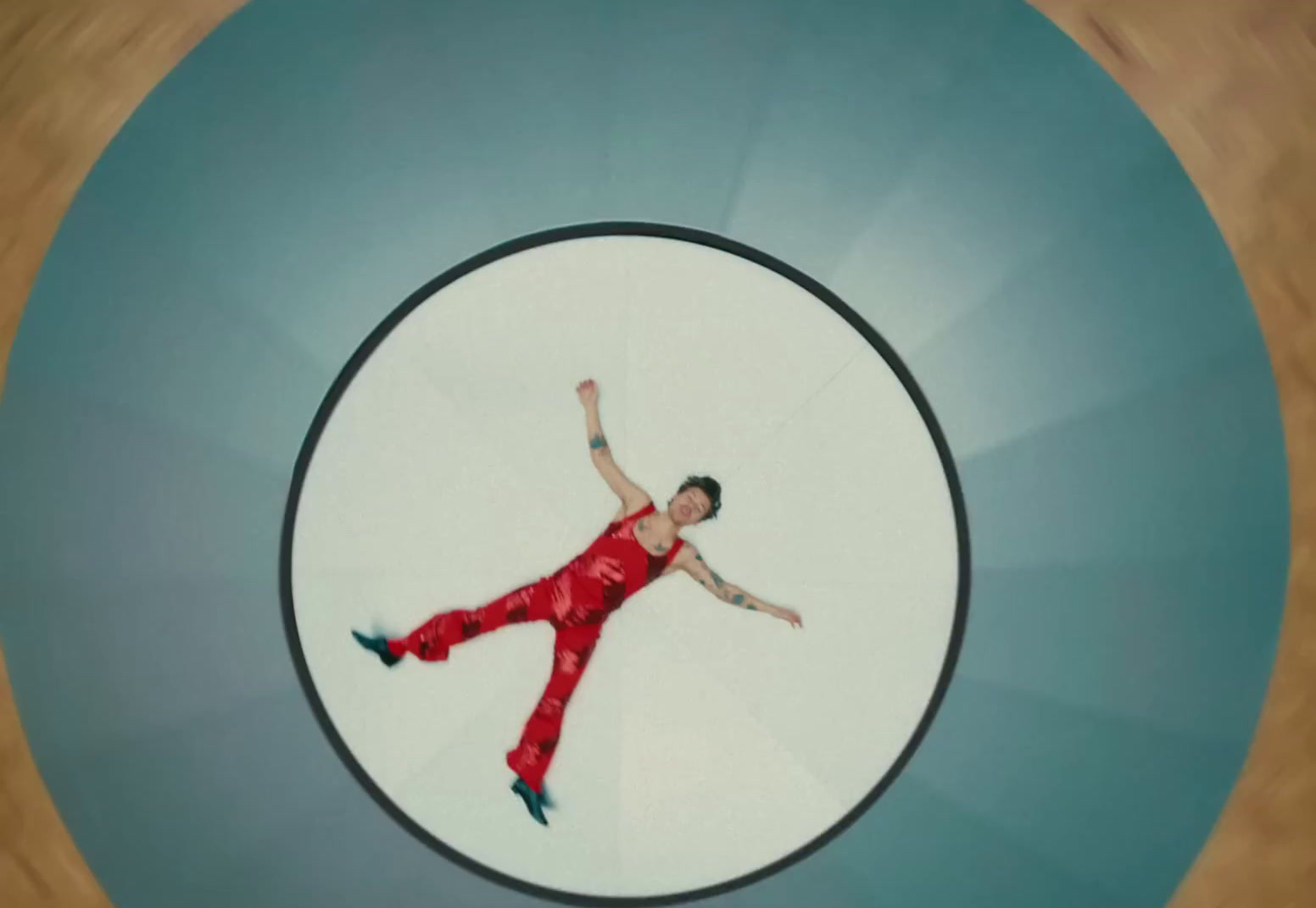 a man in a red jumpsuit in a circular picture