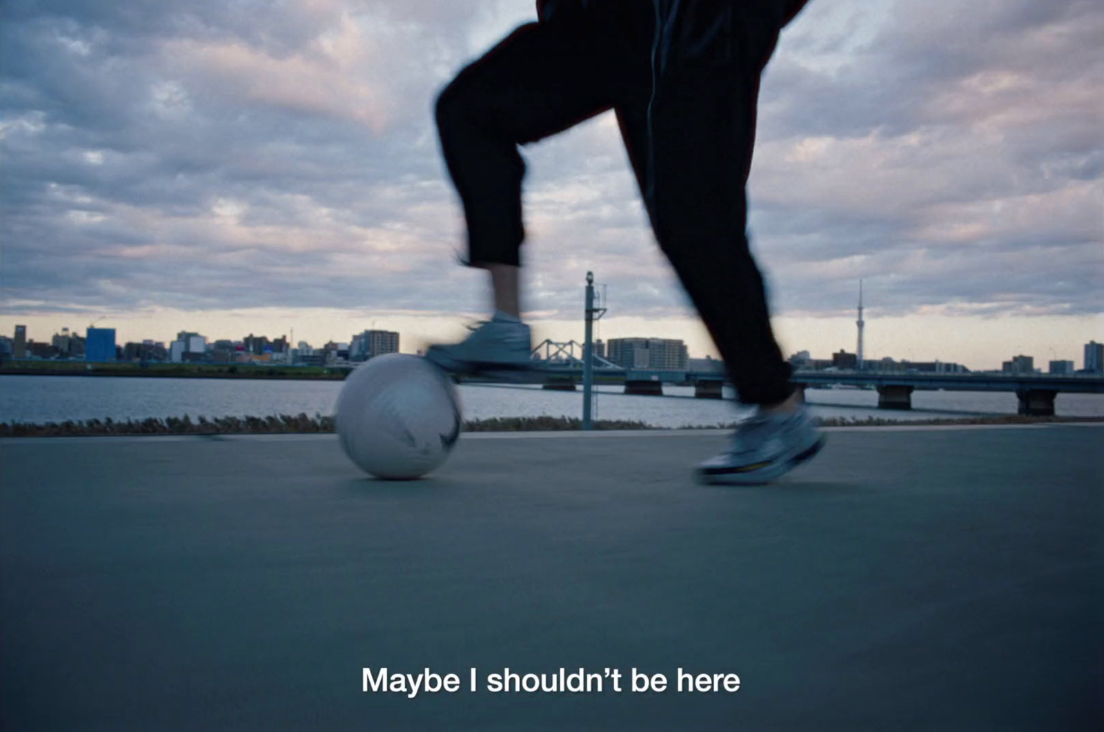 a man is kicking a soccer ball on the street