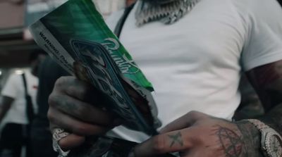 a tattooed man holding a pack of candy