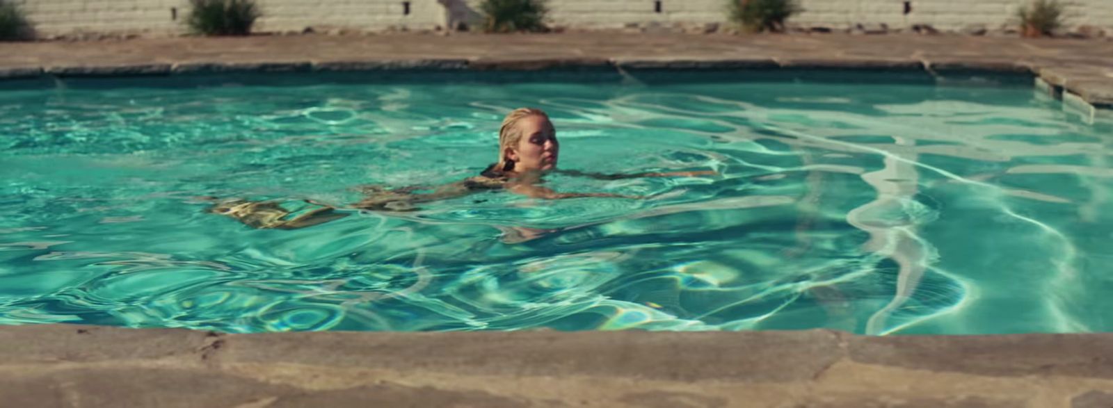 a man is swimming in a pool with a frisbee