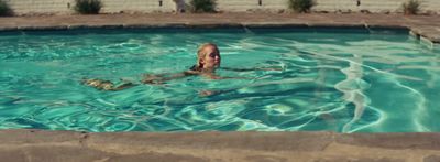 a man is swimming in a pool with a frisbee