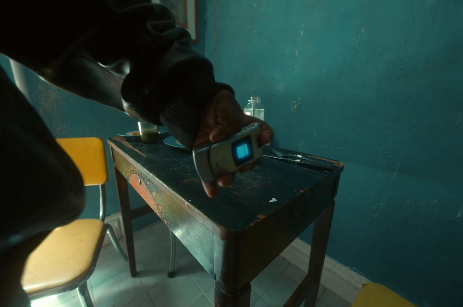 a person holding a cell phone in front of a table