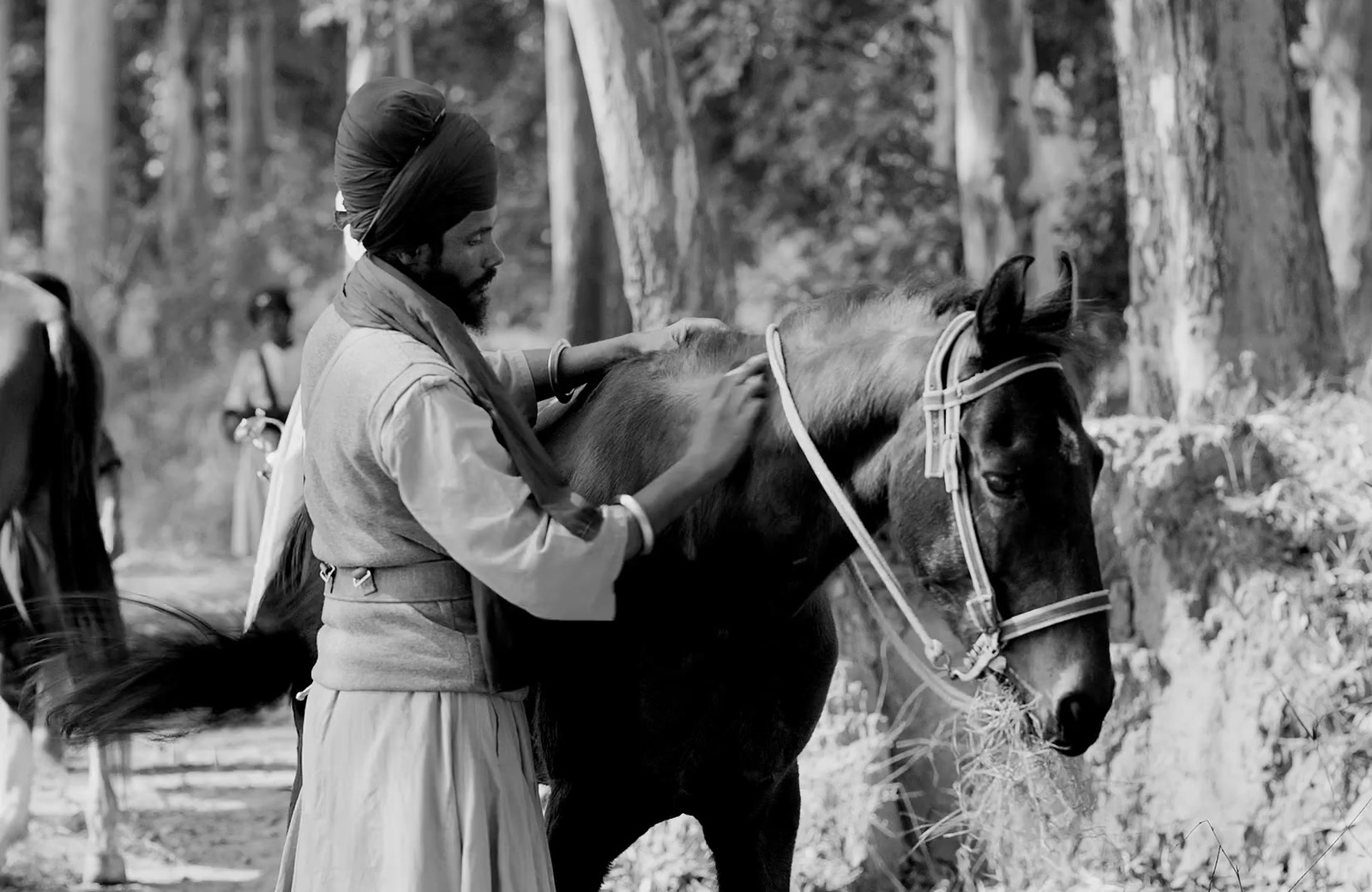 a man standing next to a horse in a forest