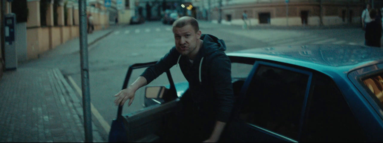 a man leaning out of a car on a city street