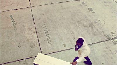 a woman in a white jacket carrying a box