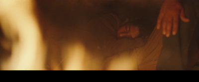 a blurry image of a person laying down in front of a fire