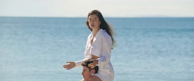 a woman standing on top of a woman on a beach