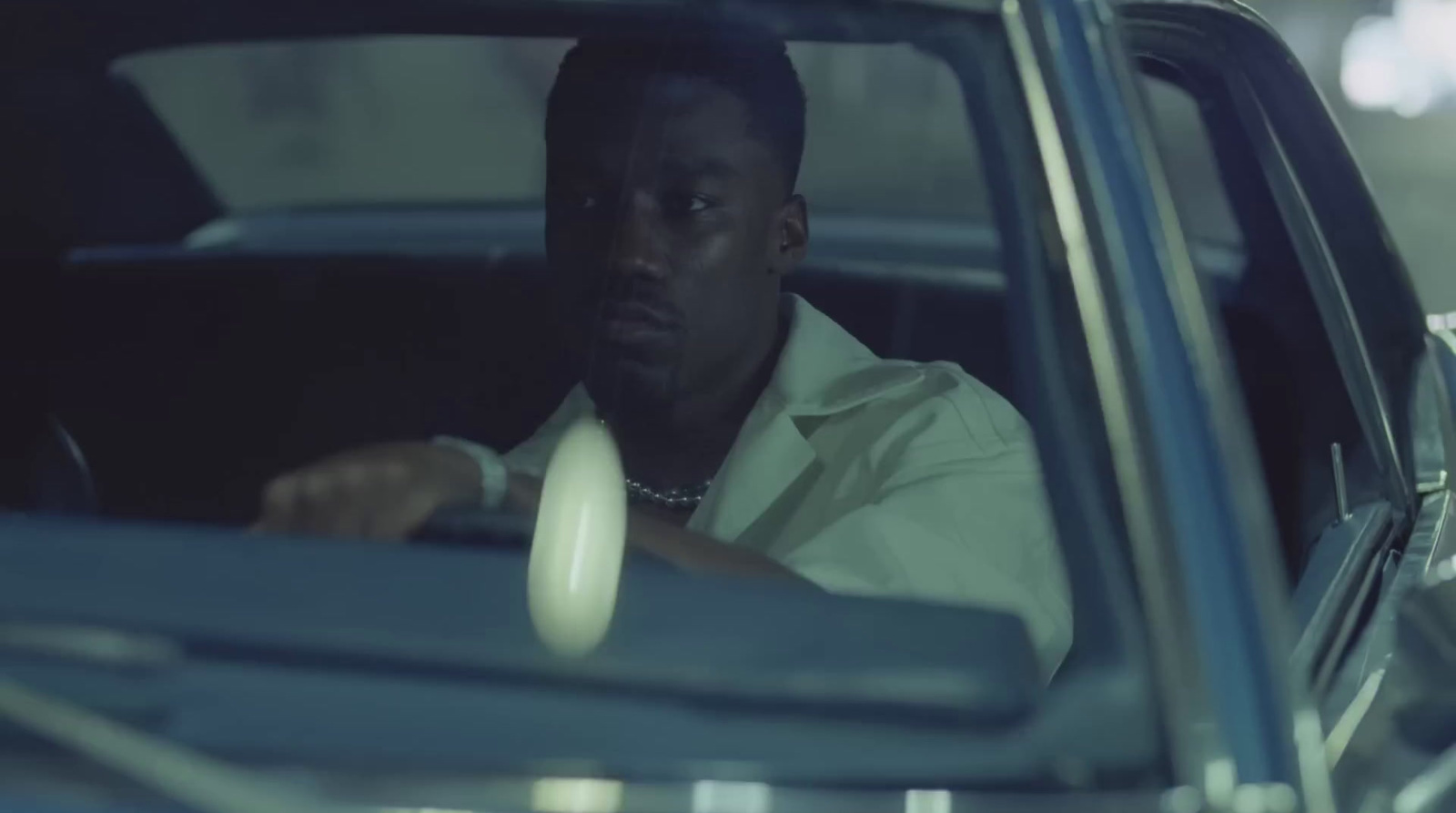 a man driving a car in a parking lot