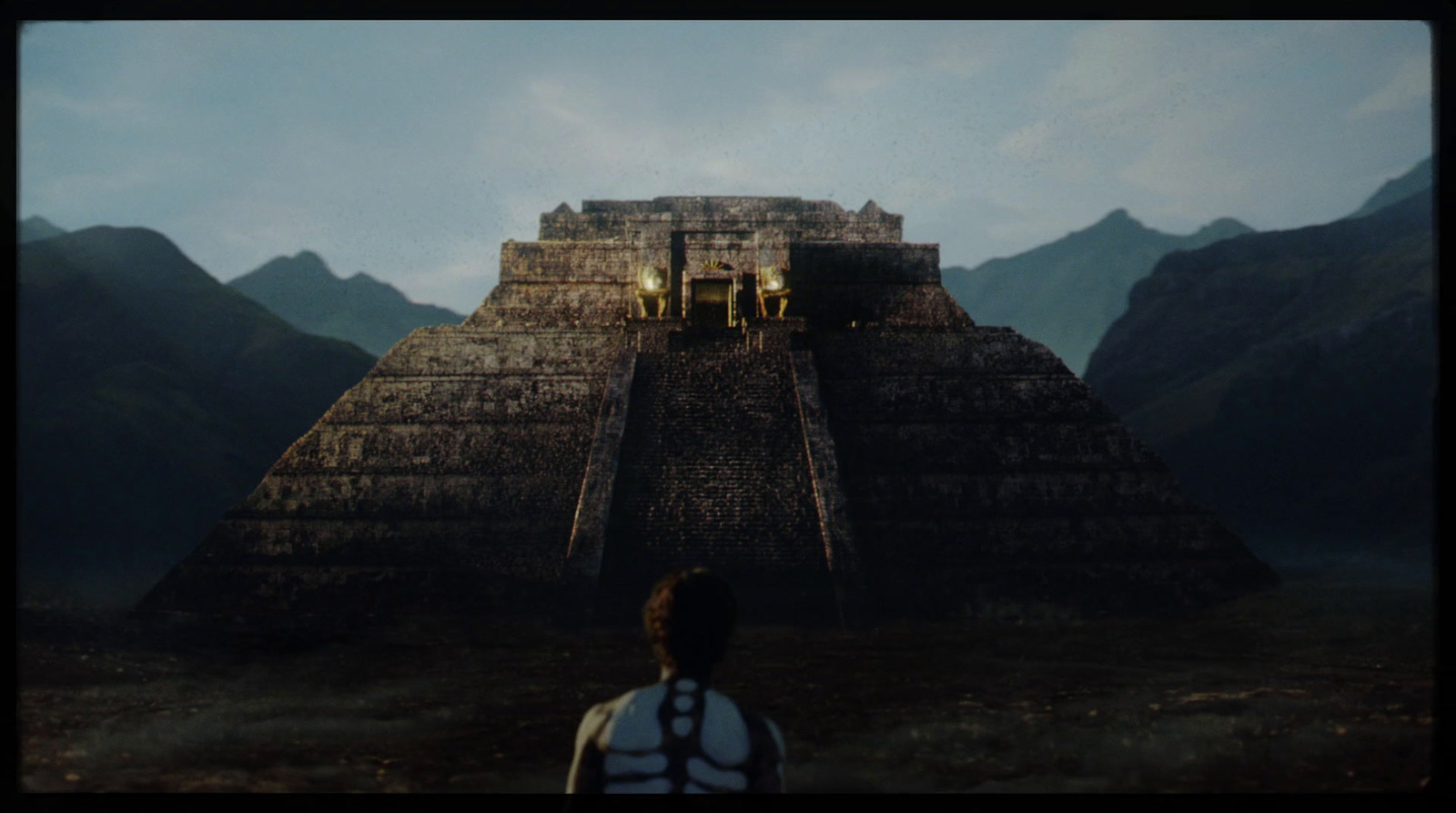 a man standing in front of a pyramid