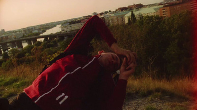 a man in a red jacket is sitting on a hill