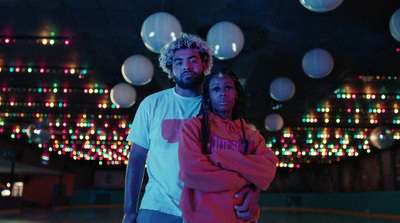 a man and a woman standing in front of a ceiling of lights