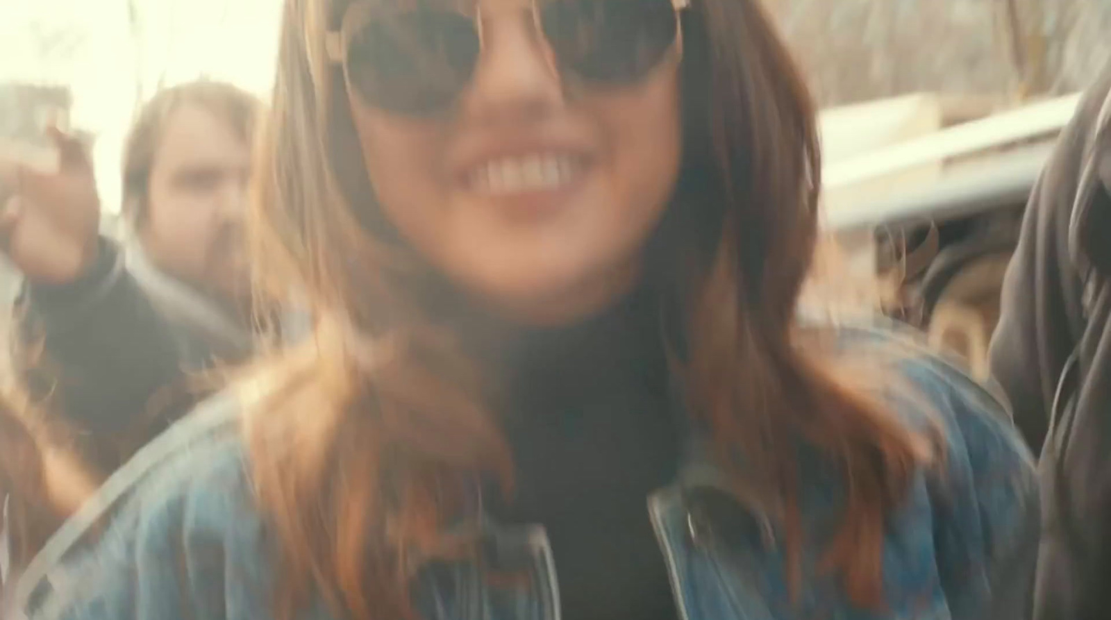 a woman wearing sunglasses and a denim jacket