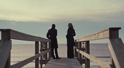 a couple of people standing on top of a pier