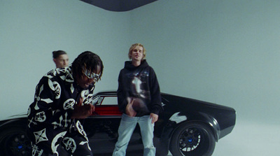 three people standing in front of a black car