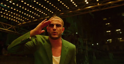 a man in a green jacket and sunglasses