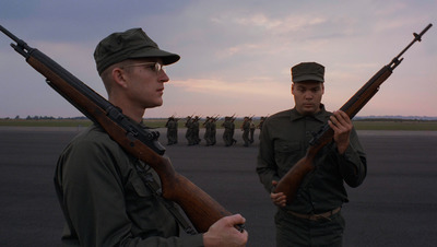 a couple of men standing next to each other holding guns