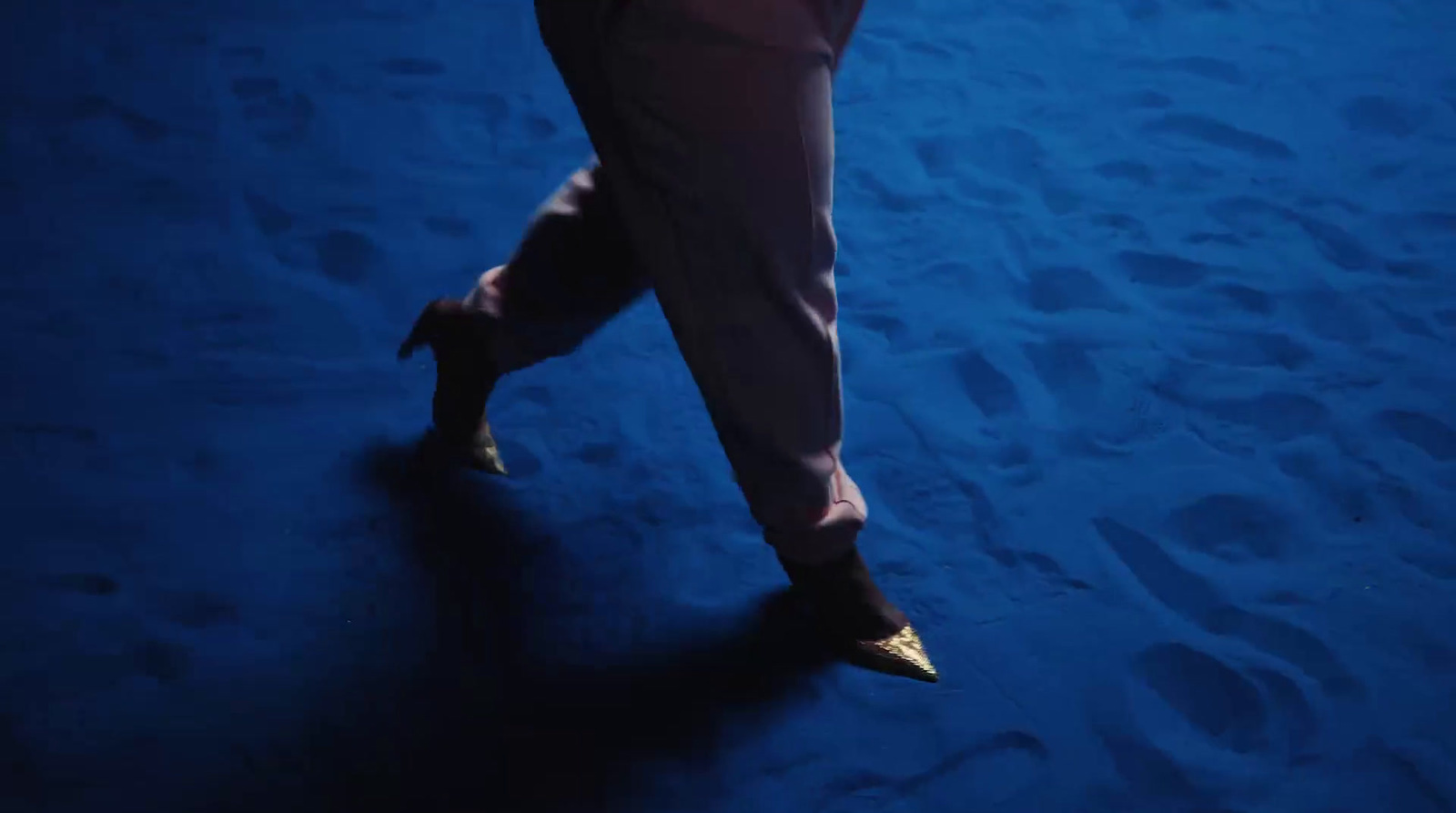 a person walking on a blue carpet with their foot in the air