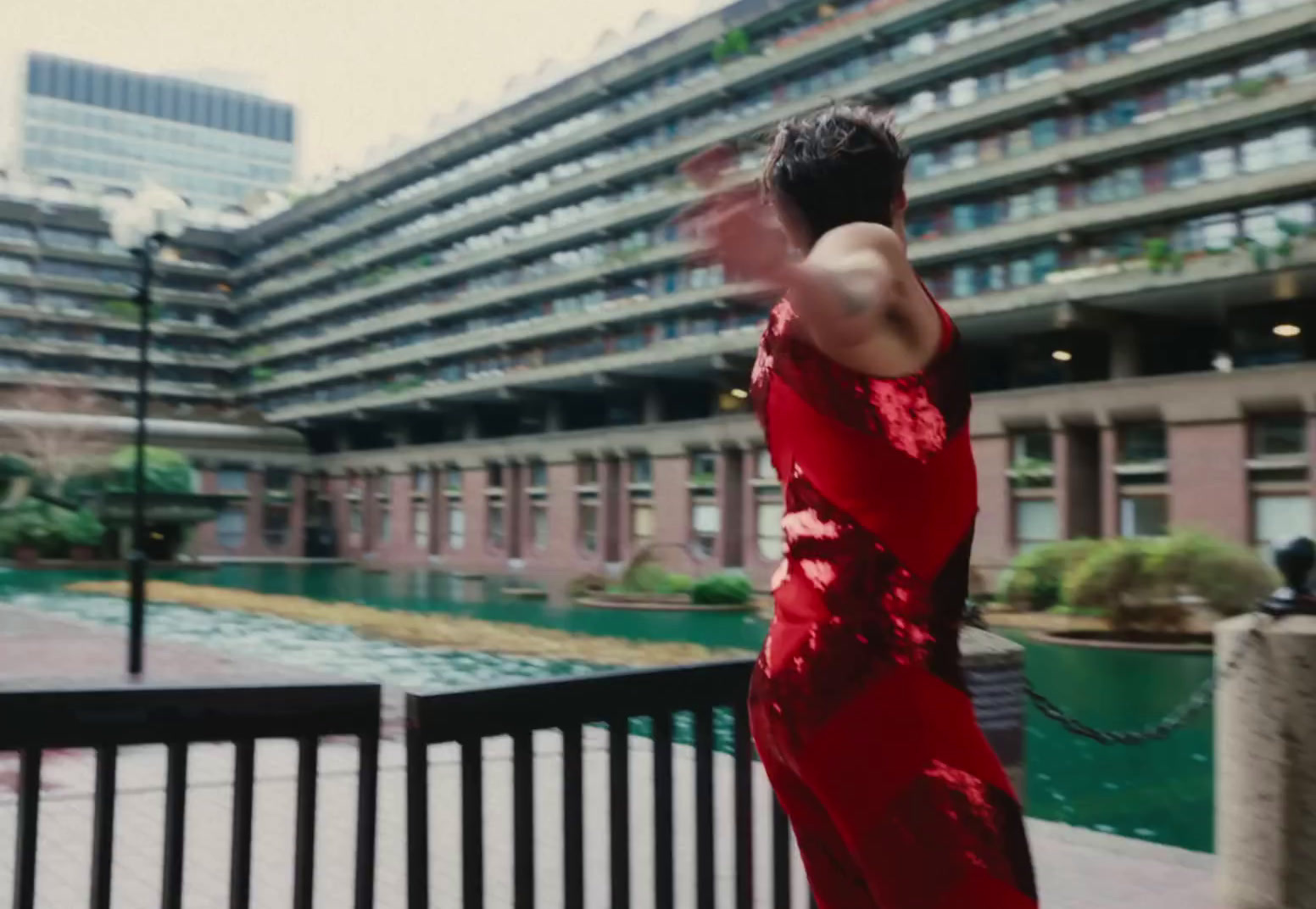 a woman in a red dress standing in front of a building