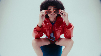 a woman wearing a red jacket and sunglasses