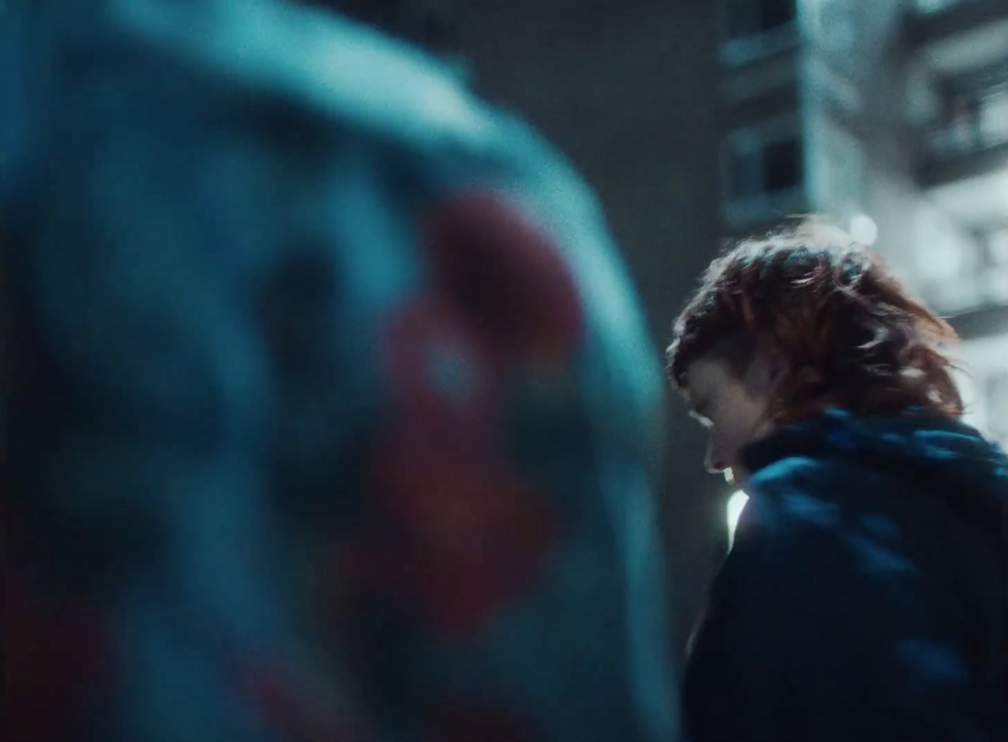 a woman with red hair standing in front of a building