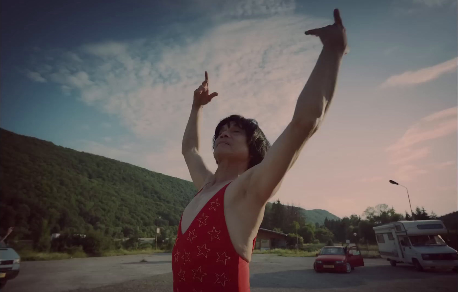 a woman in a red swimsuit standing in a parking lot