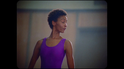 a woman with her eyes closed wearing a purple leotard