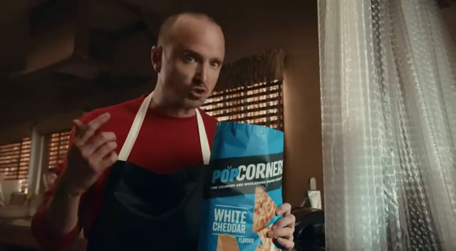 a man in an apron holding a bag of food