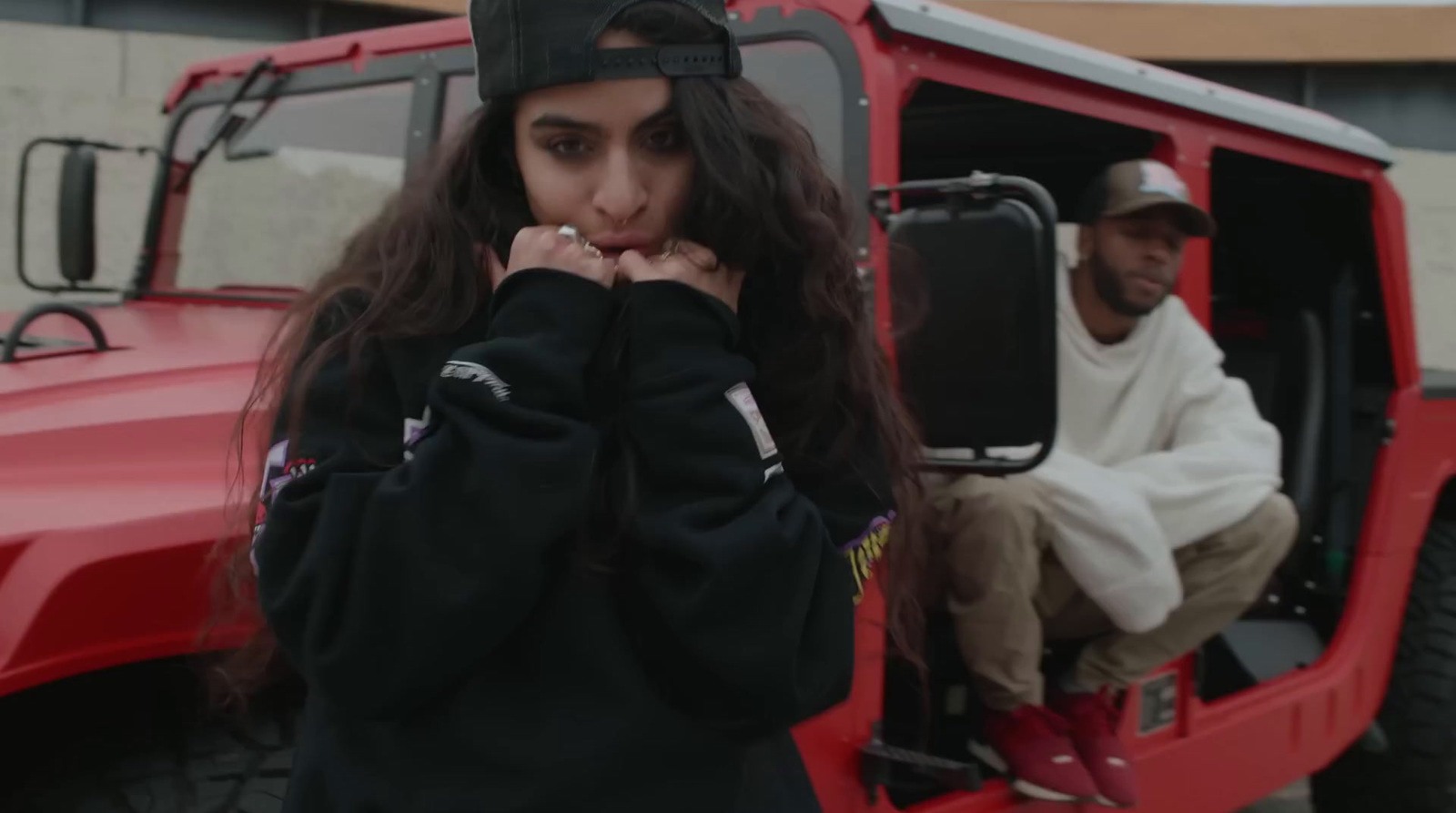 a woman sitting in the driver's seat of a red jeep