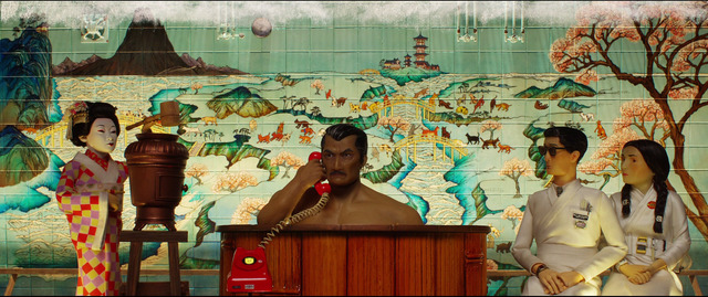 a man and two women are sitting in front of a mural