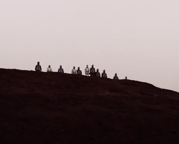 a group of people sitting on top of a hill