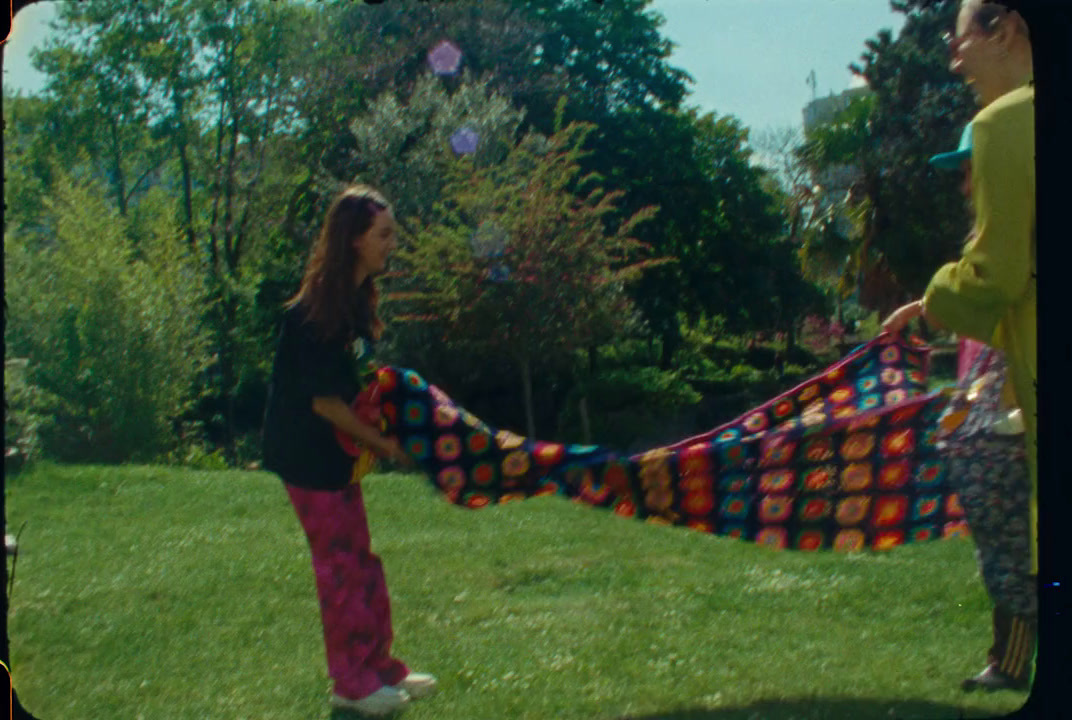 a woman holding a colorful blanket in a yard