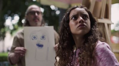 a man and a woman holding a drawing of a face