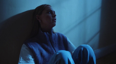 a woman sitting on the floor in a dark room