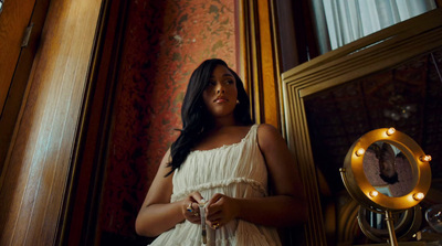 a woman in a white dress standing in front of a mirror