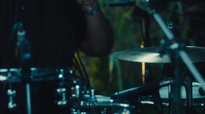 a man playing drums in a dark room