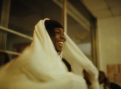 a smiling woman wrapped in a white cloth