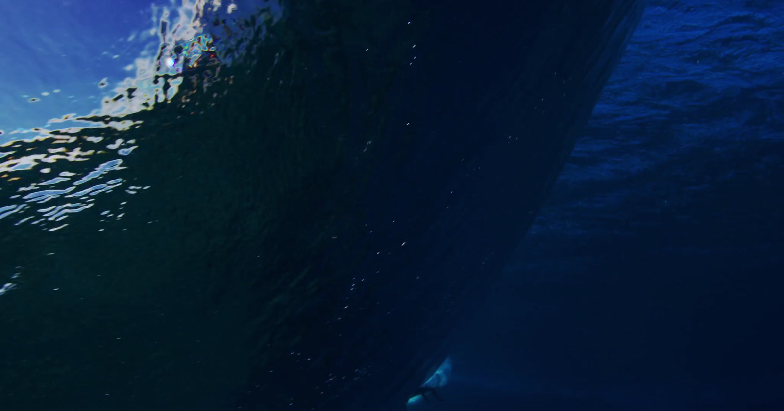 a man riding a surfboard under a wave in the ocean