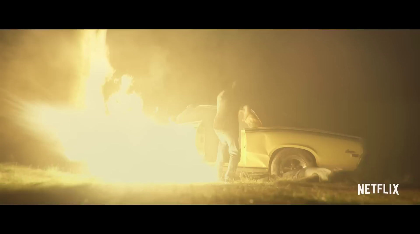 a person standing next to a yellow car