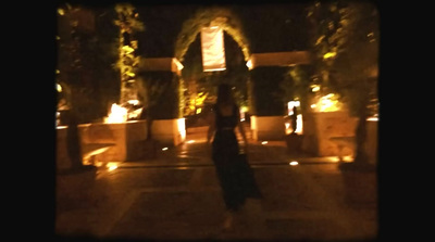 a woman in a black dress is standing in front of a building