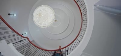 a person standing on a spiral staircase in a building