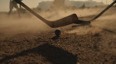 a field hockey goalie hitting a ball with a stick