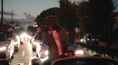 a man standing on the back of a car in traffic