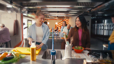 a group of people standing around a kitchen