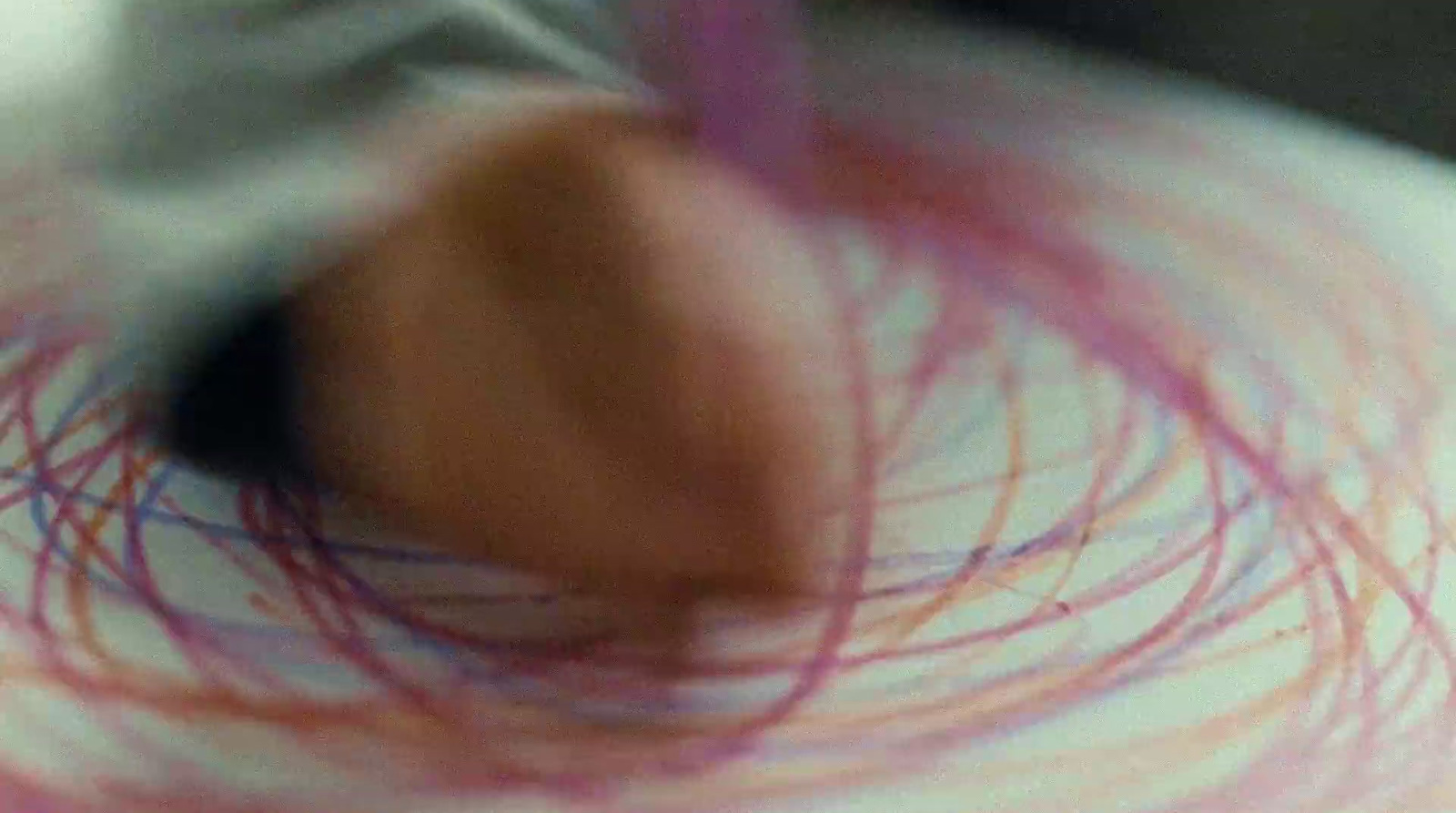 a blurry photo of a person's hand with a red object in the