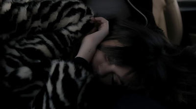 a woman laying on top of a bed covered in a blanket