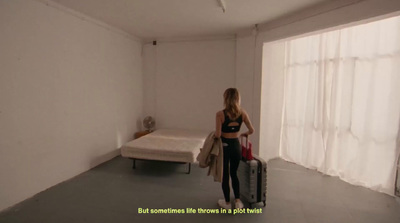 a woman standing in a room with a suitcase