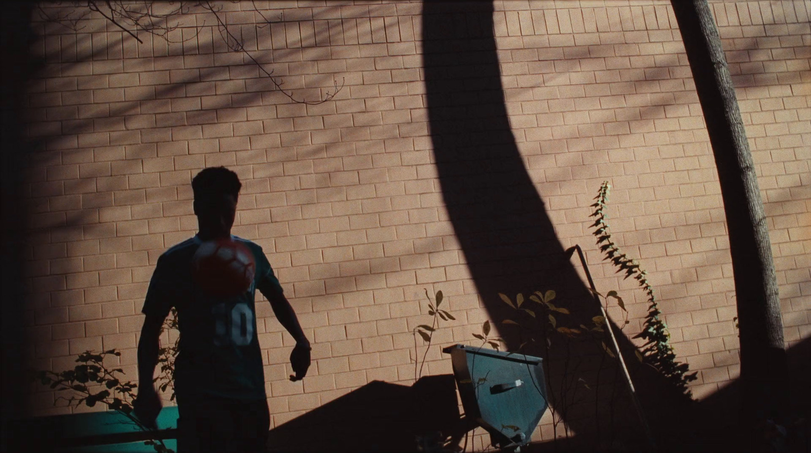 a man standing in front of a brick wall