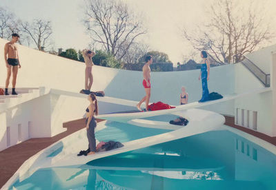 a group of people standing around a swimming pool