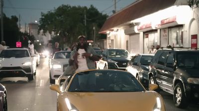 a man standing next to a yellow sports car